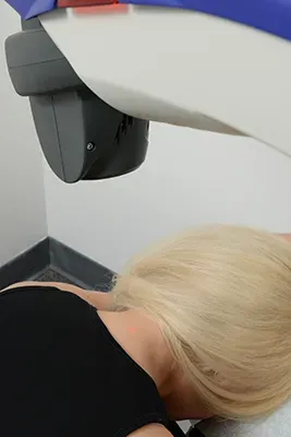 Therapy equipment positioned above a patient lying face down during a treatment session.