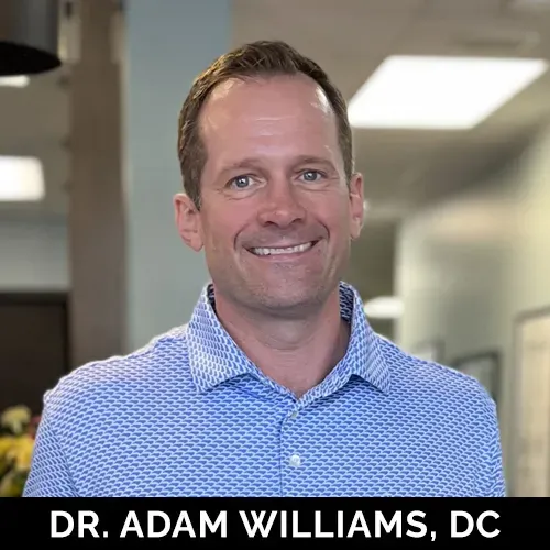 Dr. Adam Williams, a chiropractor at The Optimal Health Chiropractic wearing a blue shirt